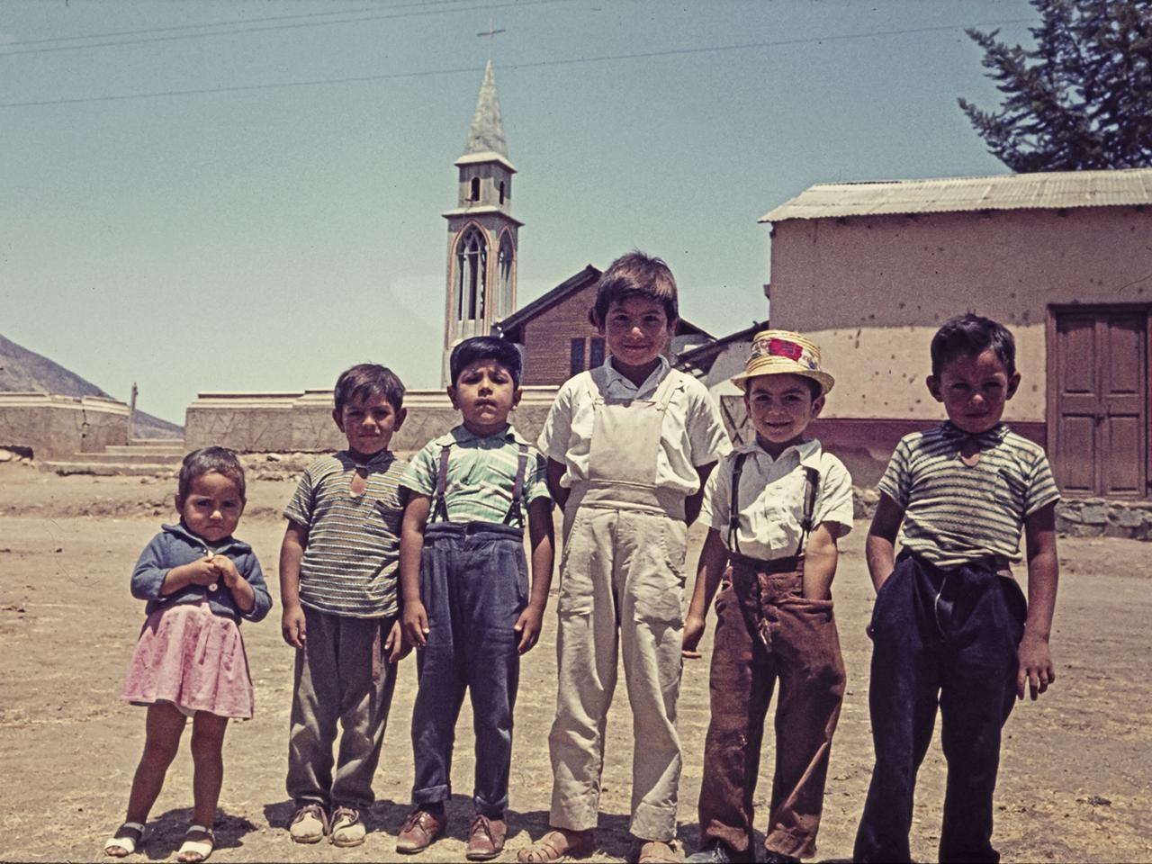 Niña y niños retratados en el frontis de la iglesia parroquial