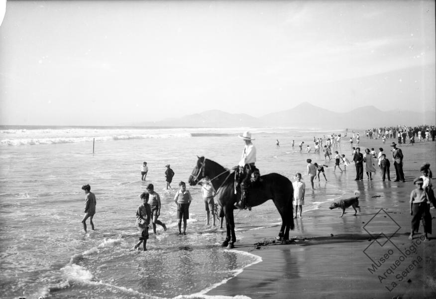 Playa de La Serena. Vista de la playa hacia el sur, personas y un jinete Playa de La Serena. Vista de la playa hacia el sur, personas y un jinete