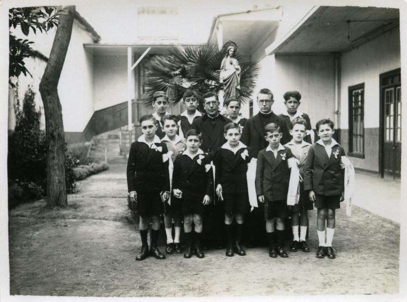 Niños en Primera Comunión junto al padre Gronkowski (der.)