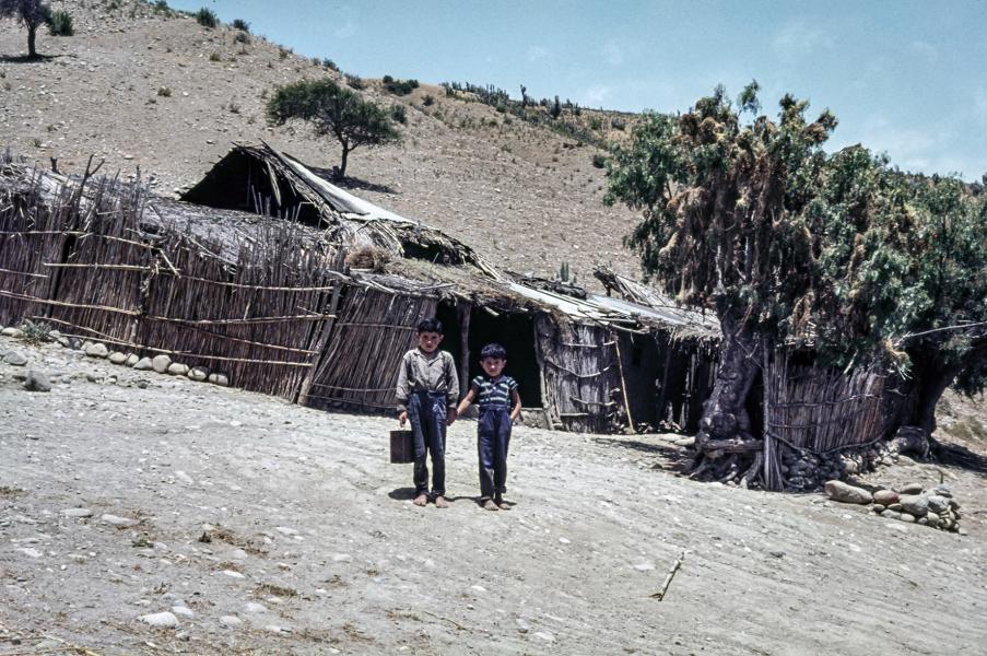 Niños posando frente a un rancho